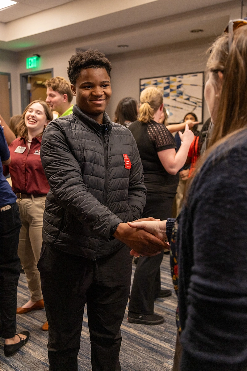 male student shaking the hand of a female student.