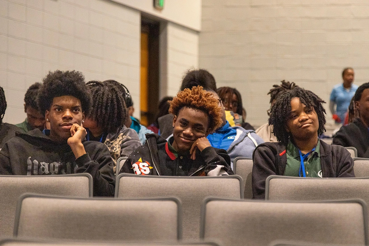 three students sitting in an auditorium