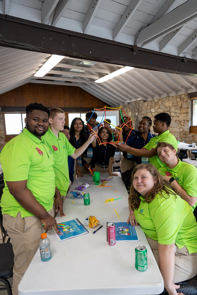 CTI students at a long table in bright green shirts