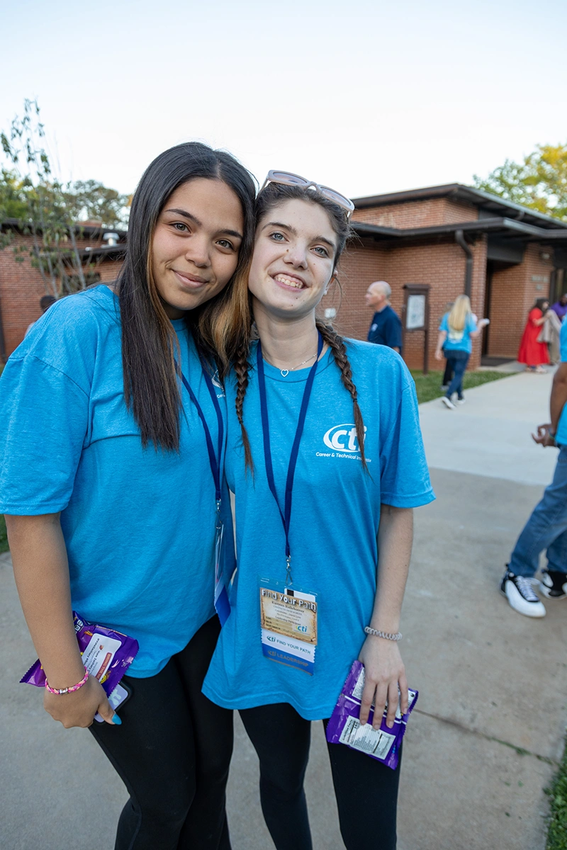 two female students in blue shirts embracing