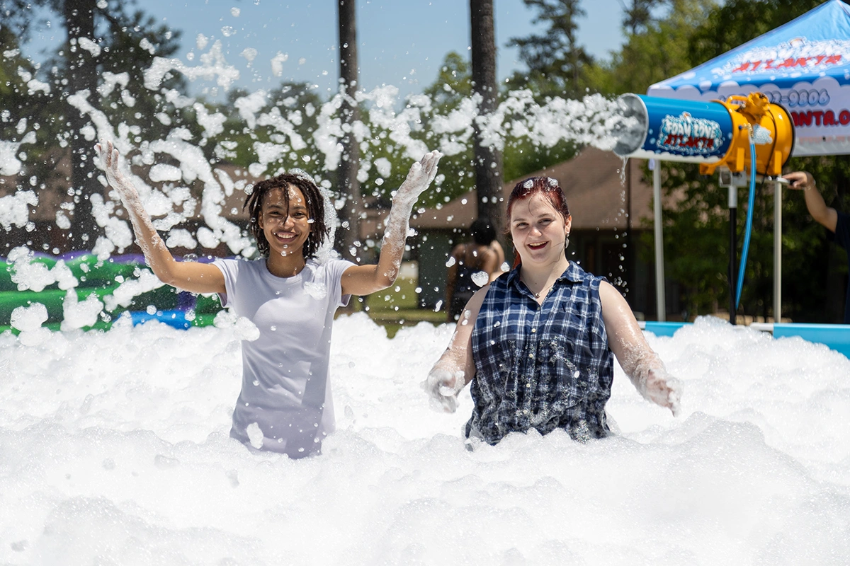 two female students surrounded by a cloud of bubbles